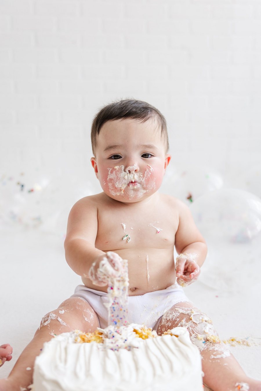 Toddler enjoying a cake-smash moment at a second birthday